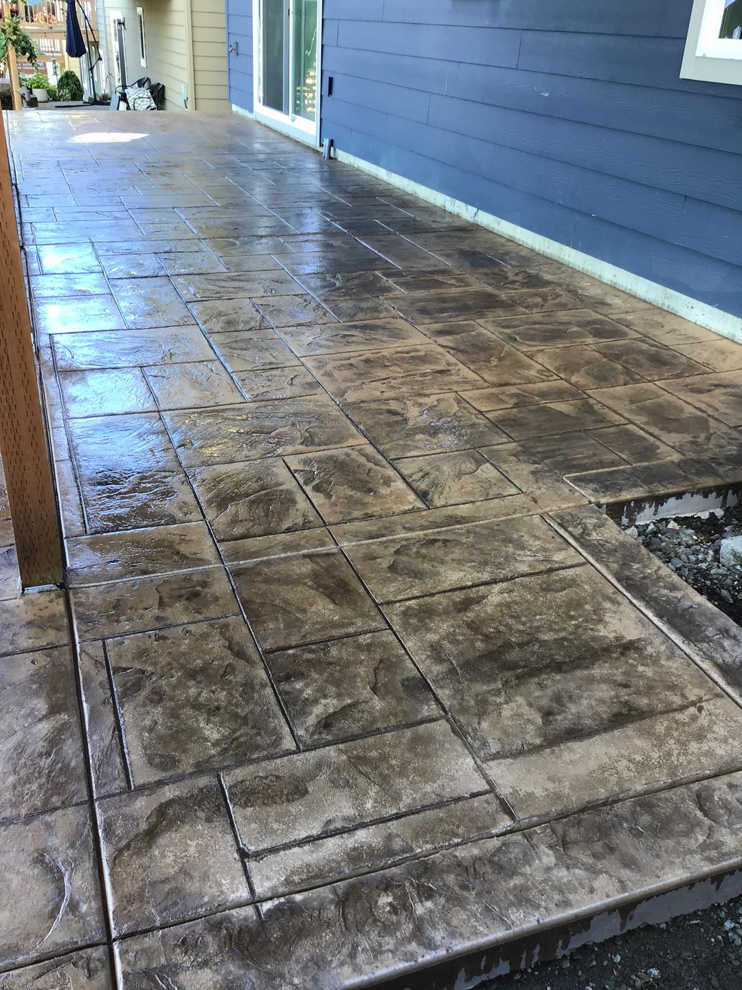 Exposed aggregate walkway with stamp concrete border along house