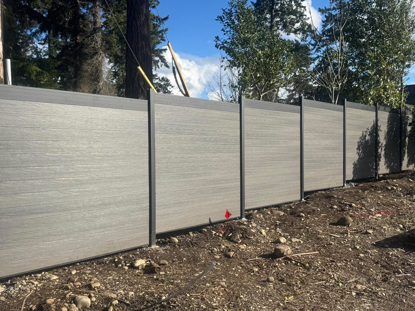 Modern horizontal fence installation with composite panels and steel posts